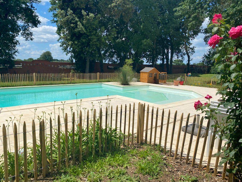 Ganivelle basse installée en bordure entourant un massif à proximité de la piscine