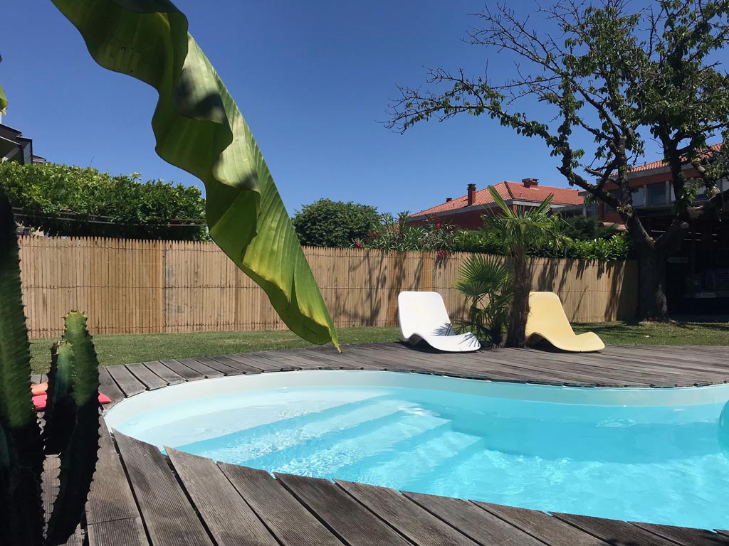 Ganivelles en lattes quasi-jointives qui clôturent un jardin et sa piscine 
